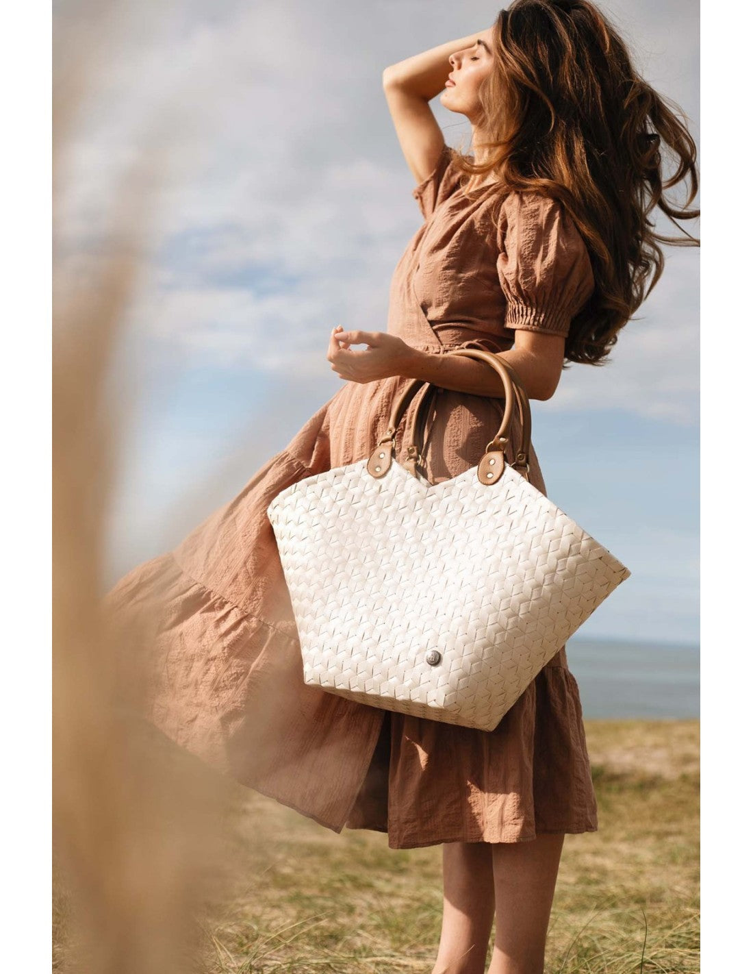 Mujer con bolso shopper tejido en color blanco con asas de cuero, ideal para un look elegante y natural, disponible en Cobalto Accesorios