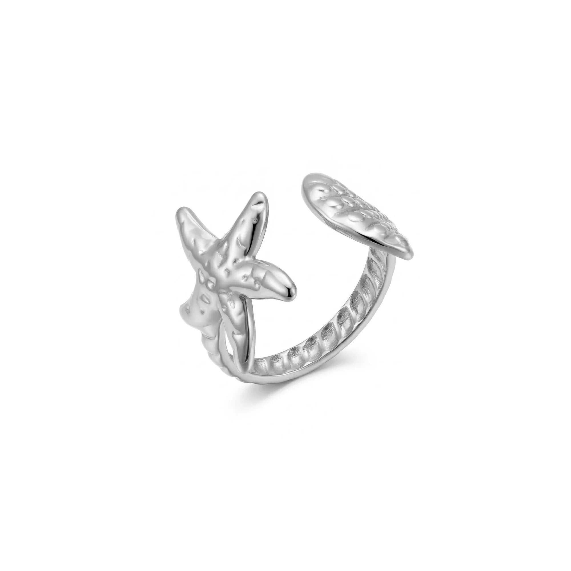 Anillo abierto plateado con estrella de mar, concha y aro texturizado sobre fondo blanco