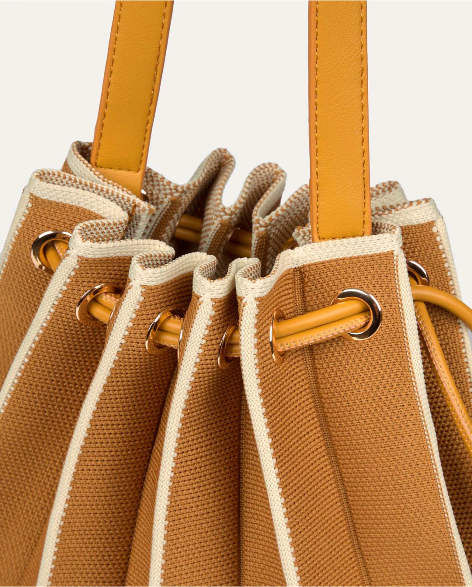 Detalle del cierre de cordón y ojales metálicos dorados del bolso de punto plisado camel - Cobalto Accesorios Valencia
