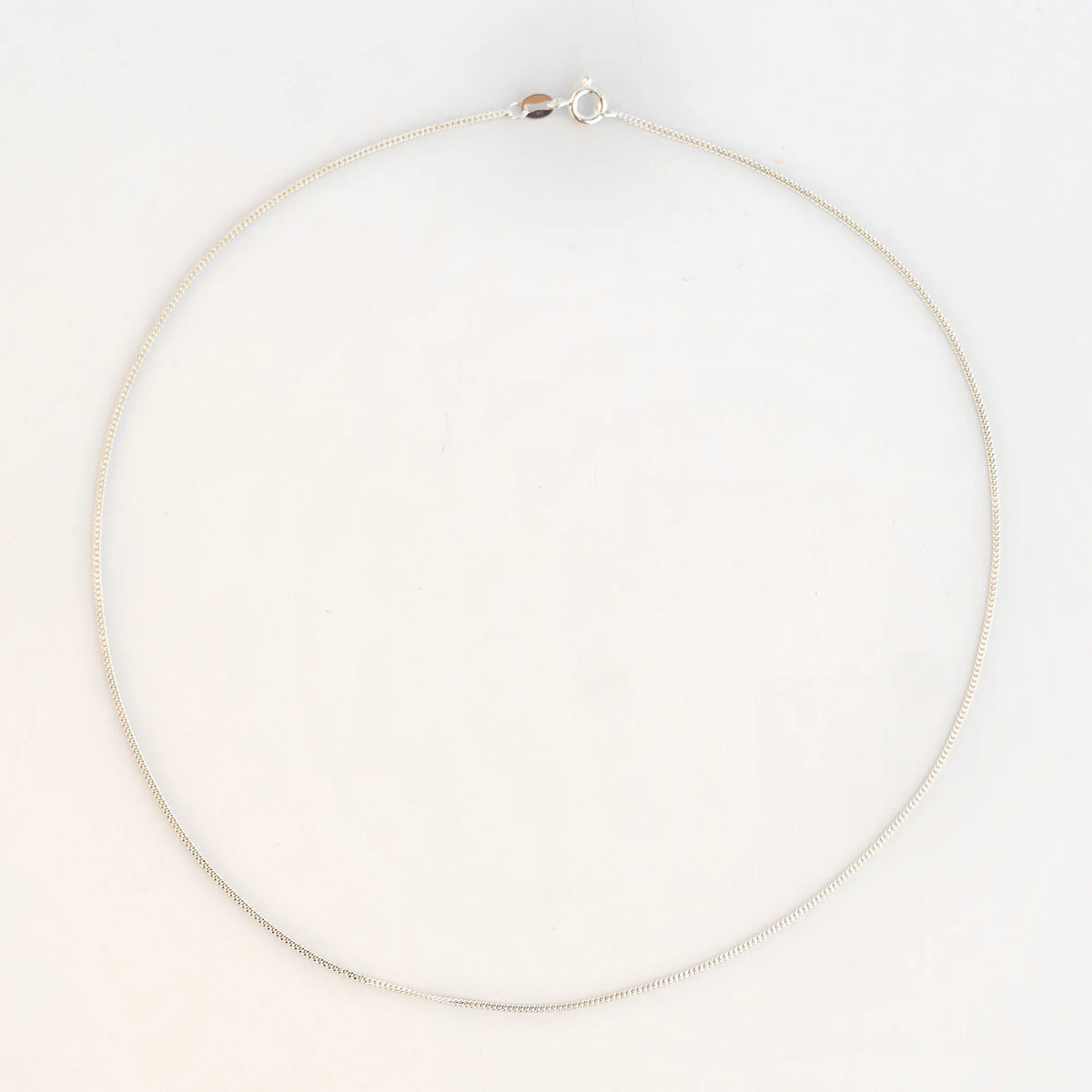 Cadena barbada 035 en plata de ley de 45 cm, extendida en círculo sobre fondo blanco