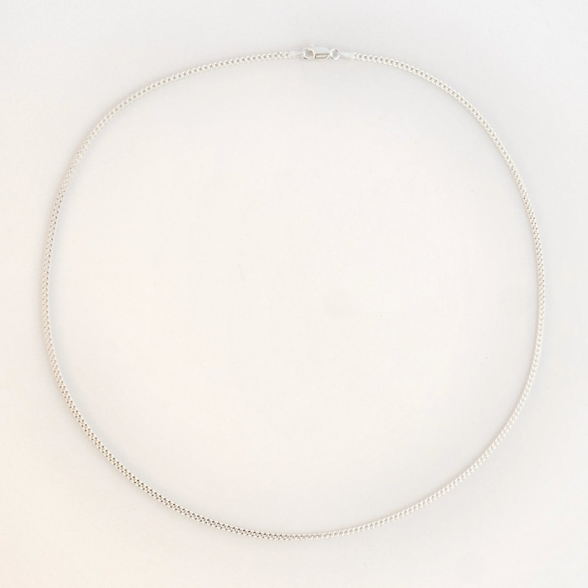 Cadena barbada 060 en plata de ley de 50 cm, la más gruesa de la serie, extendida en círculo