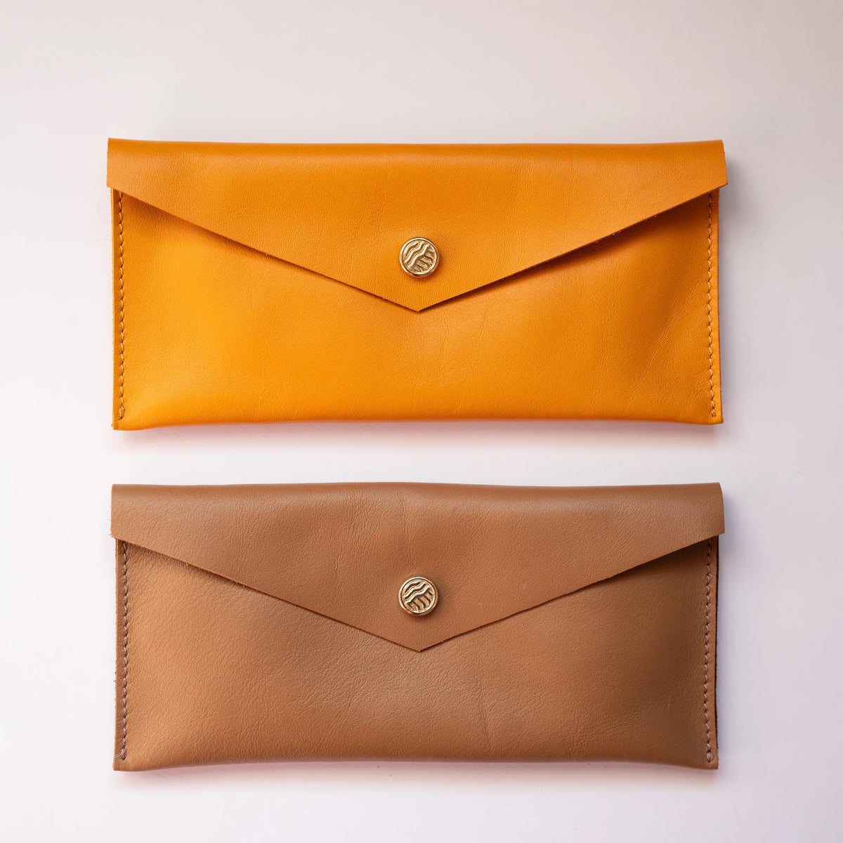 Carteras sobre alargadas de piel en mostaza y camel