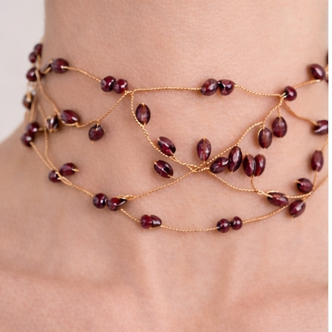 Choker Liana color vino con cuentas y diseño entrelazado en cuello de mujer, vista frontal.