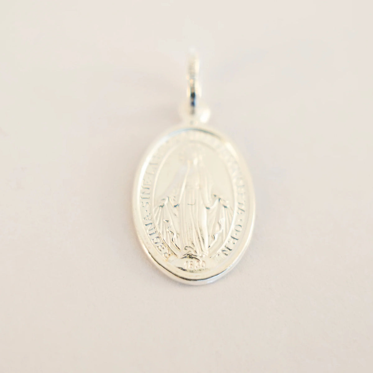 Colgante Virgen Milagrosa de plata de 16 x 11 mm sobre fondo claro