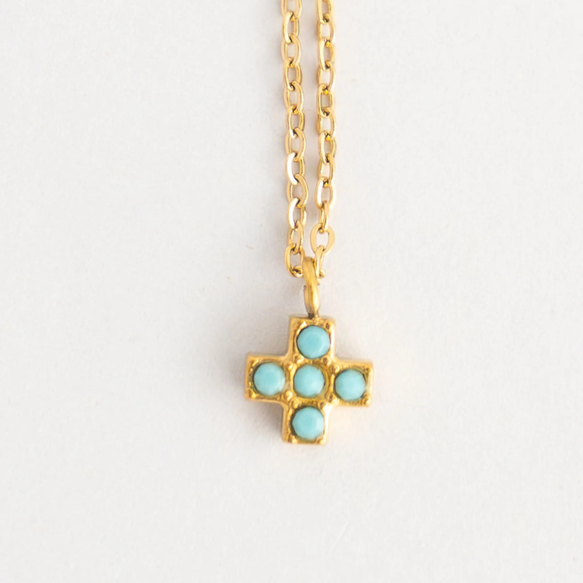 Collar cruz cuadrada con circonitas turquesa y cadena dorada