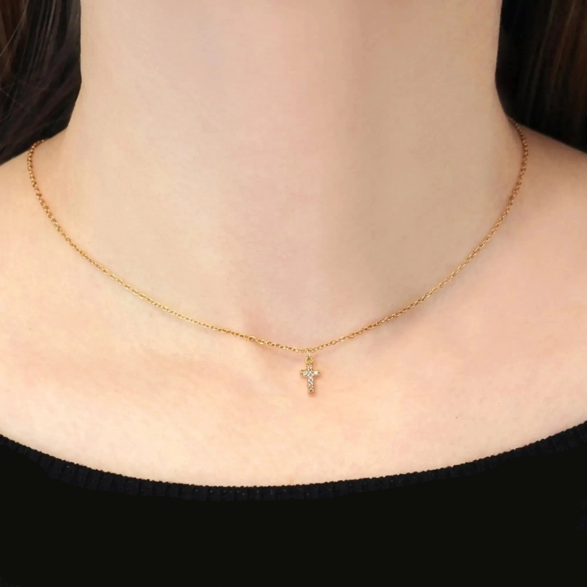 Collar dorado con cruz mini de circonitas llevado al cuello