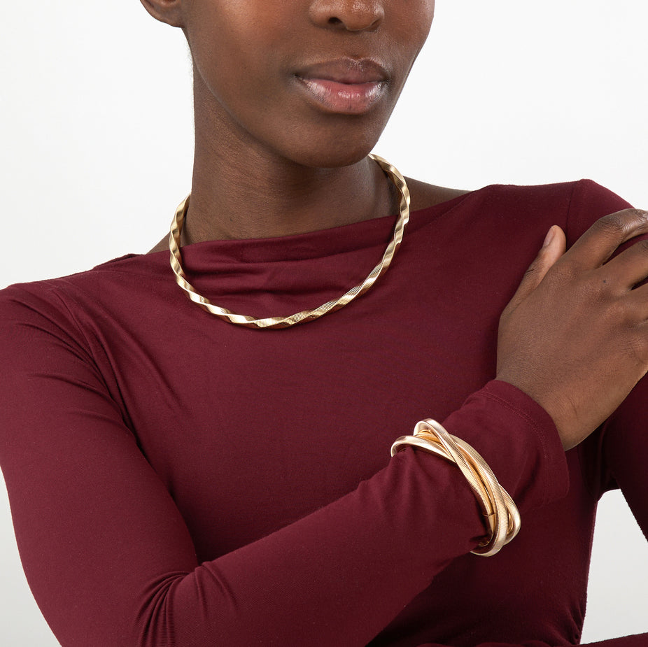 Collar Espiral Dorado sobre modelo con escote, estilo elegante y moderno