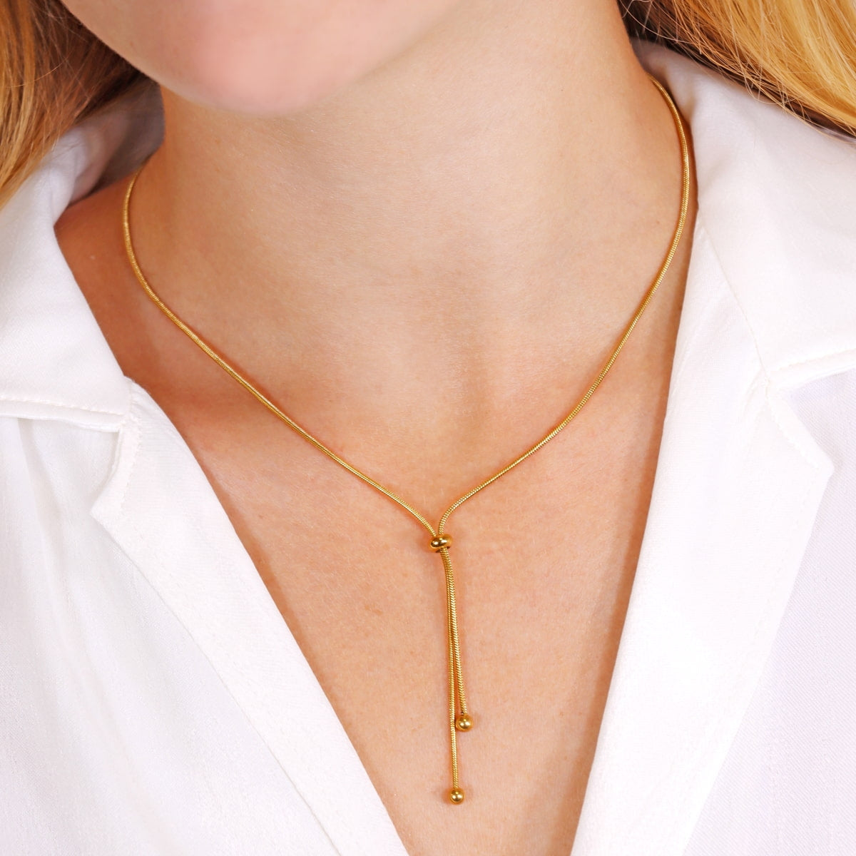 Collar Infinity Alive dorado en acero inoxidable sobre cuello de modelo, diseño ajustable y elegante