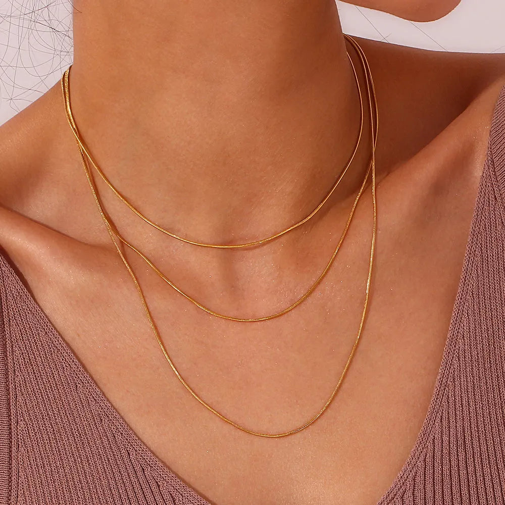 Detalle del Collar Omega dorado en acero inoxidable, pieza minimalista con presencia