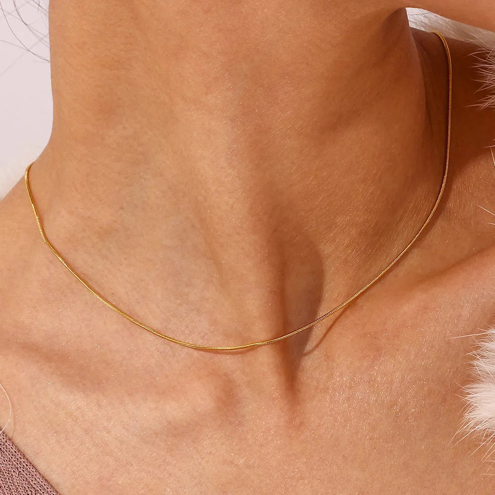 Collar Omega dorado visto de cerca, diseño limpio y versátil para combinar