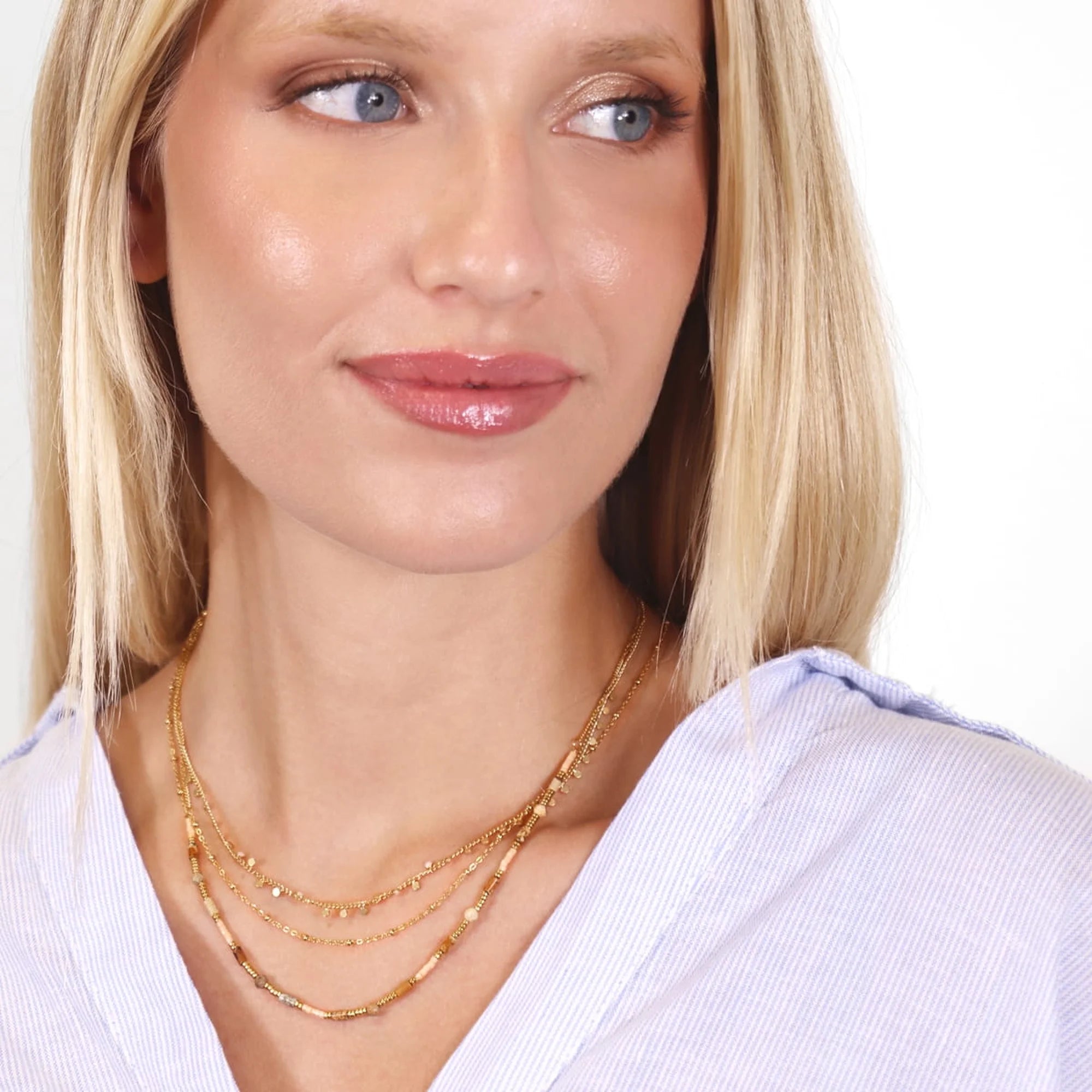 Collar triple de piedras naturales marrones visto en cuello, efecto layering