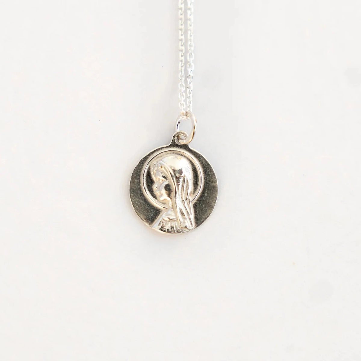 Medalla de la Virgen Niña de 16 mm en plata de ley, montada en cadena fina