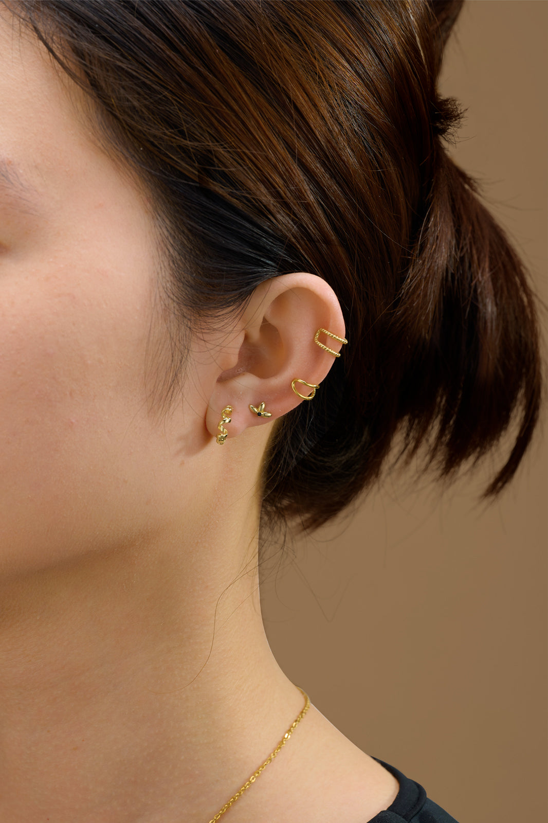 Pendiente aro espiral mini dorado de plata de ley 925 con baño de oro 18k, combinado con otros pendientes tipo piercing, Cobalto Accesorios Valencia