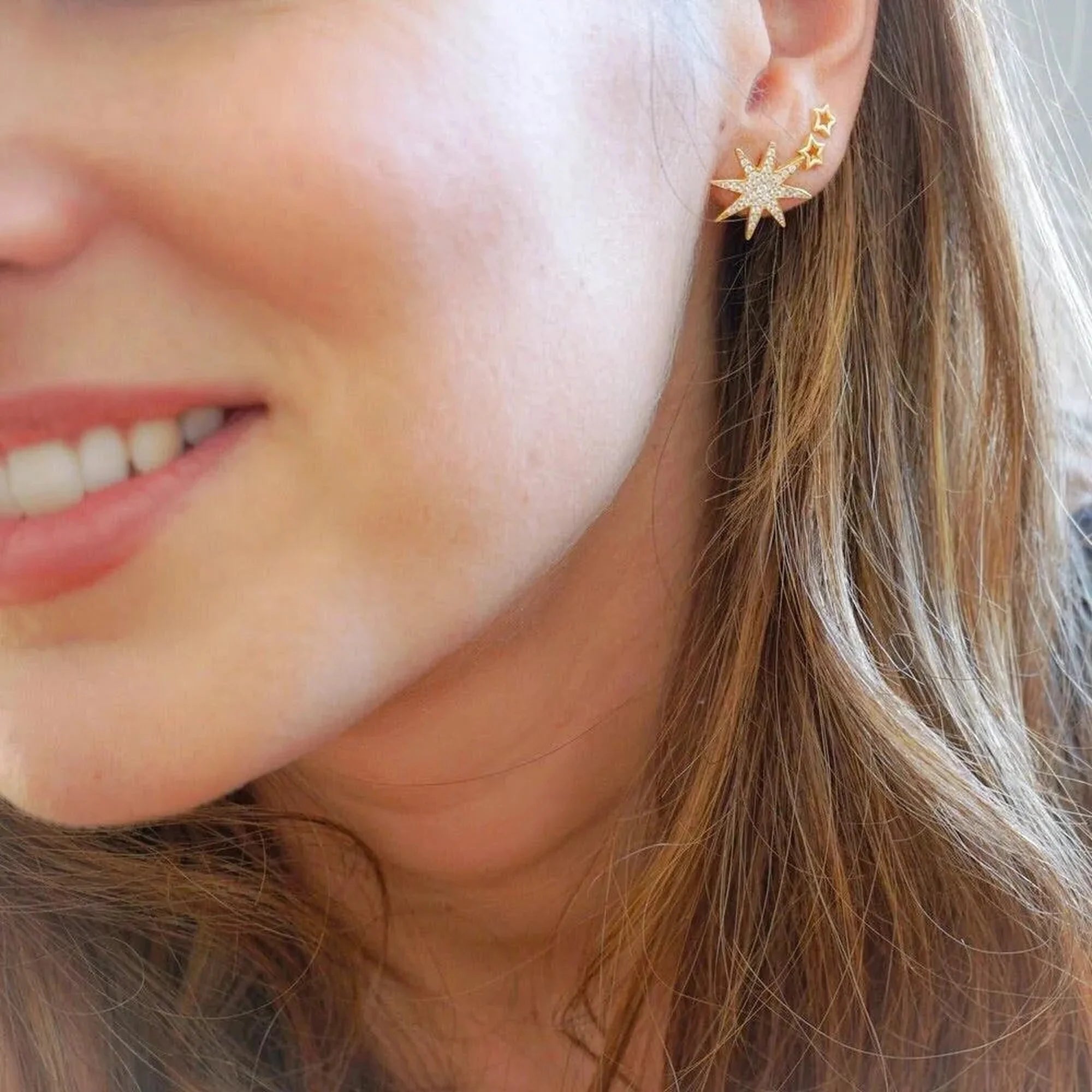 Pendiente Estrella Calada dorado combinado con otros pendientes de estrella en la oreja