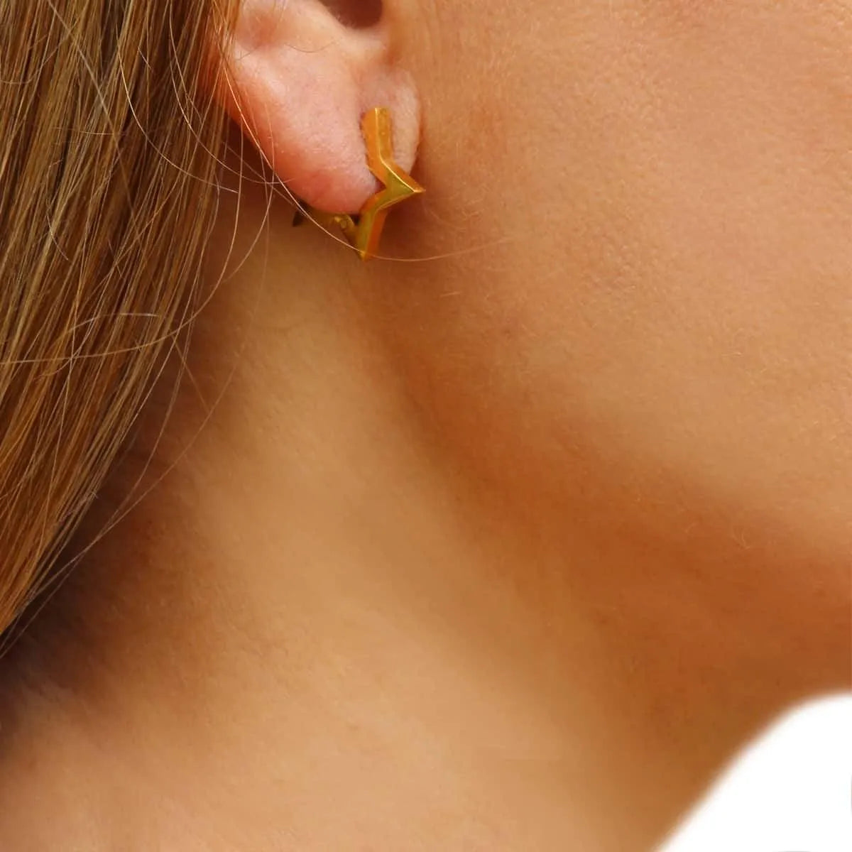Detalle de pendientes aros con forma de estrella de 16 mm, pieza moderna y llamativa