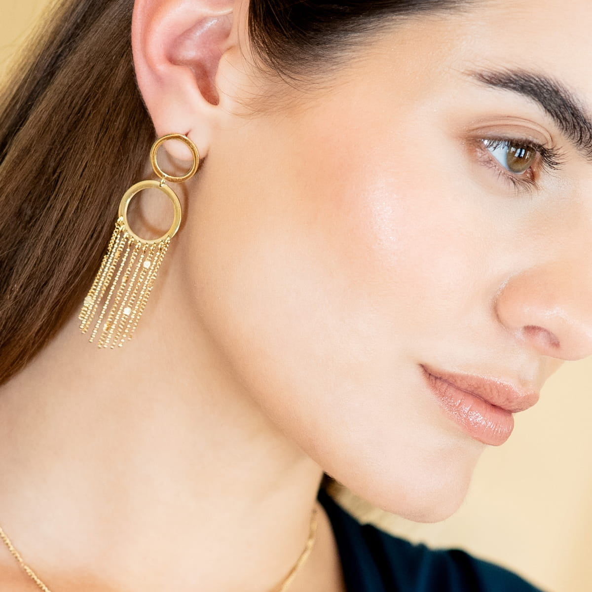 Detalle lateral de los pendientes Rainfall Aura colgantes dorados