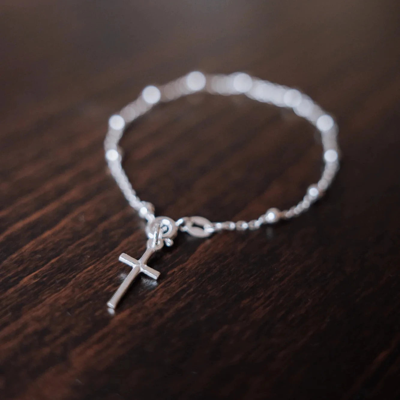 Detalle de las cuentas y la cruz de la pulsera decenario en plata de ley plateada