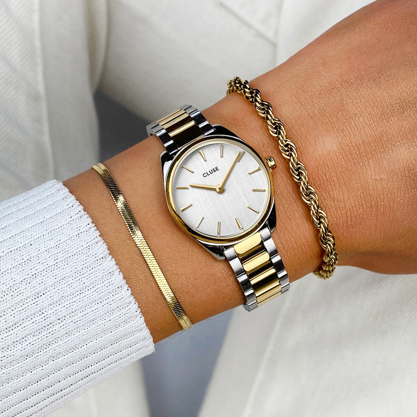 Reloj CLUSE Féroce Mini bicolor oro y plata puesto en muñeca, caja 25 mm