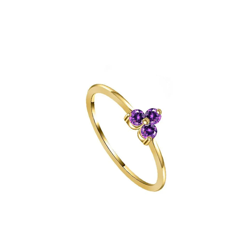 Anillo con tres circonitas de colores, diseño delicado y brillante
