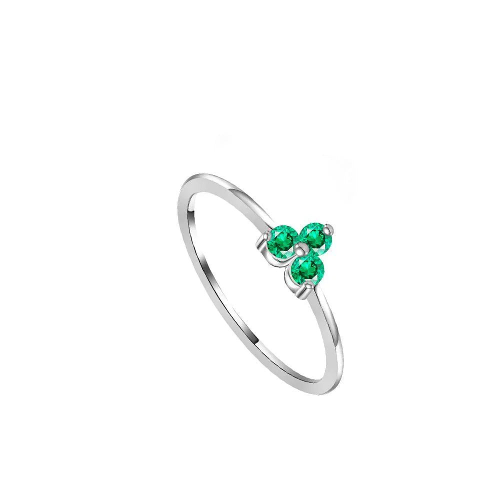 Detalle adicional del anillo de tres circonitas de colores, diseño brillante