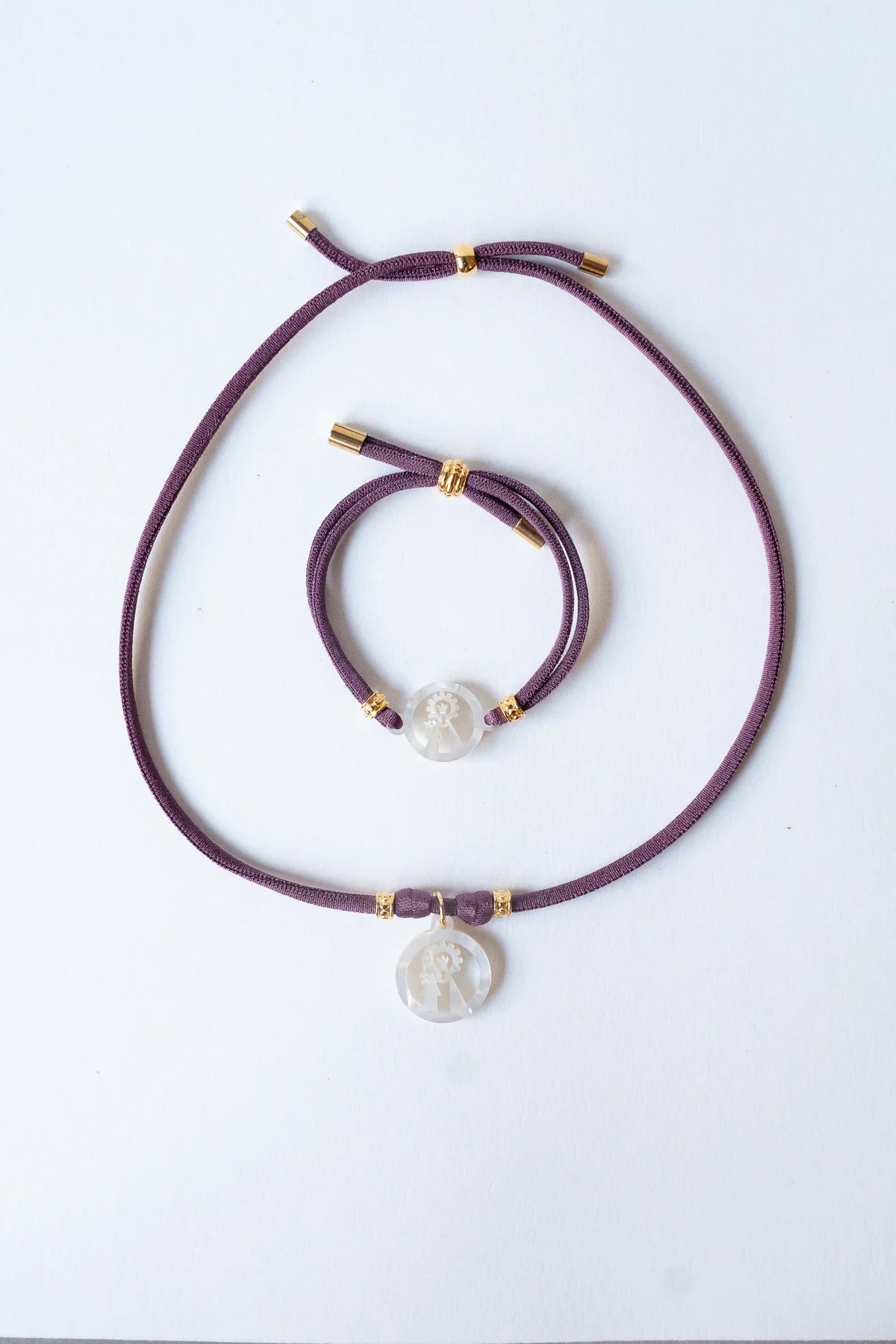 Collar y pulsera elástica de la Virgen de los Desamparados, patrona de Valencia, sobre fondo blanco