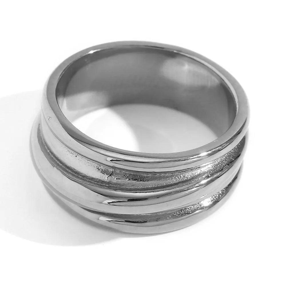 Detalle del anillo ancho de rayas en acero inoxidable, acabado trabajado
