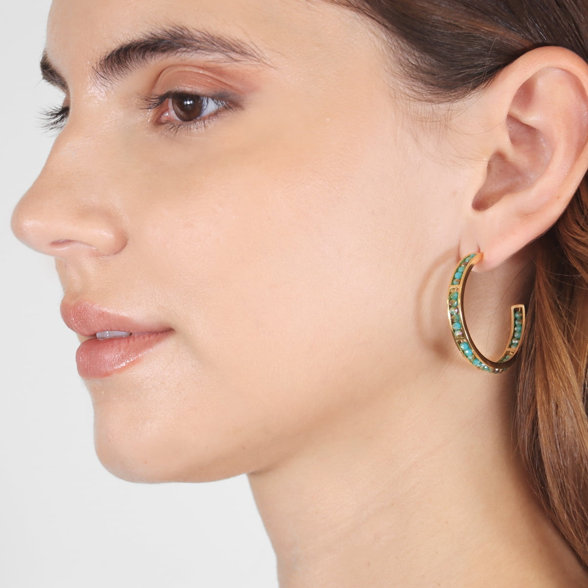 Aros Levity Sassy dorados con cristales multicolor en modelo