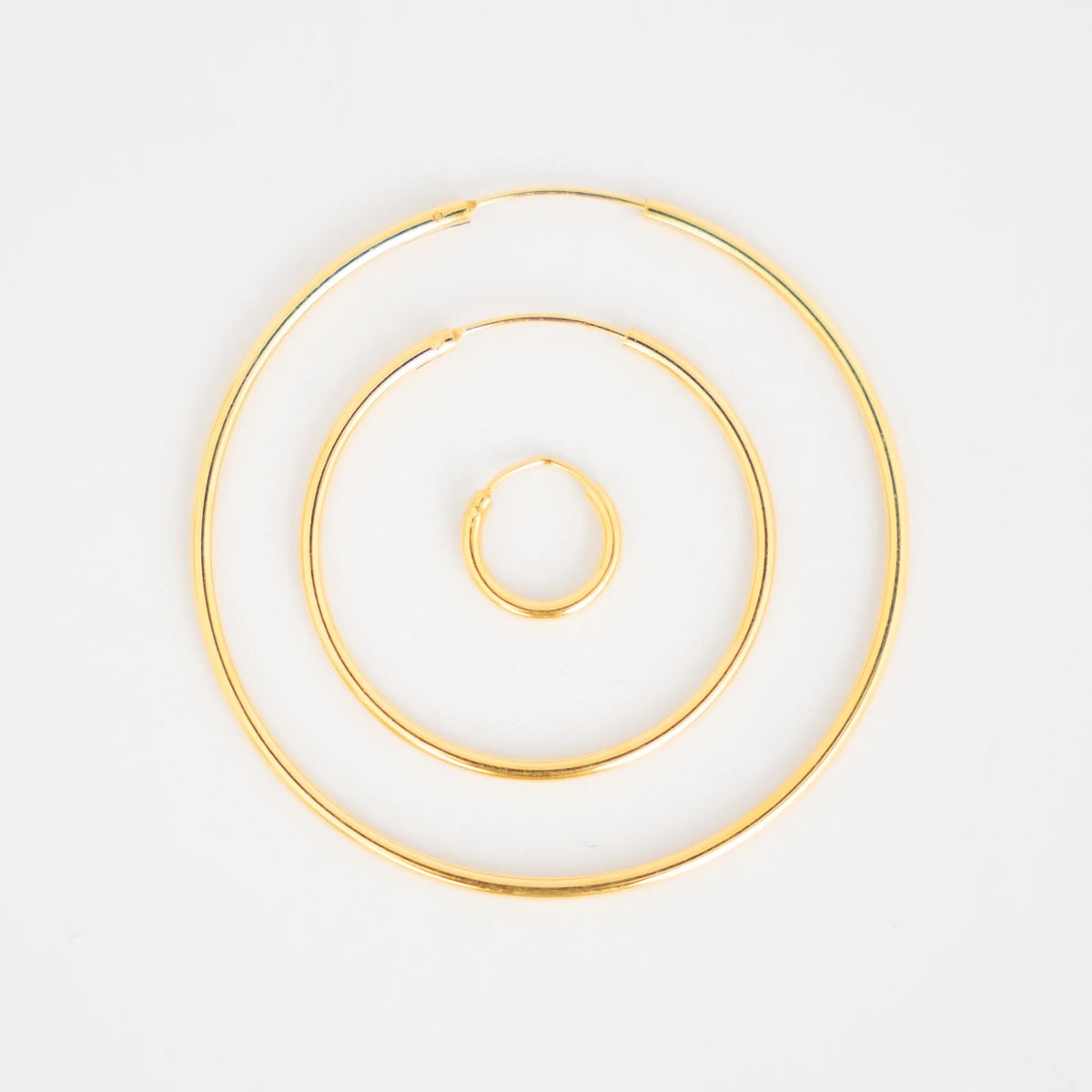 Aros de plata dorados de 10, 30 y 45 mm juntos para comparar el tamaño