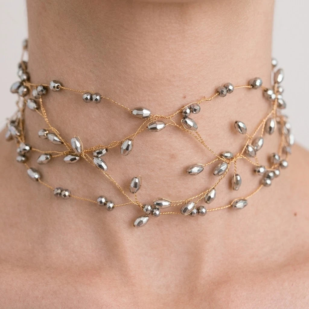 Detalle del Choker Liana plateado en el cuello: cristales facetados plateados sobre hilo dorado