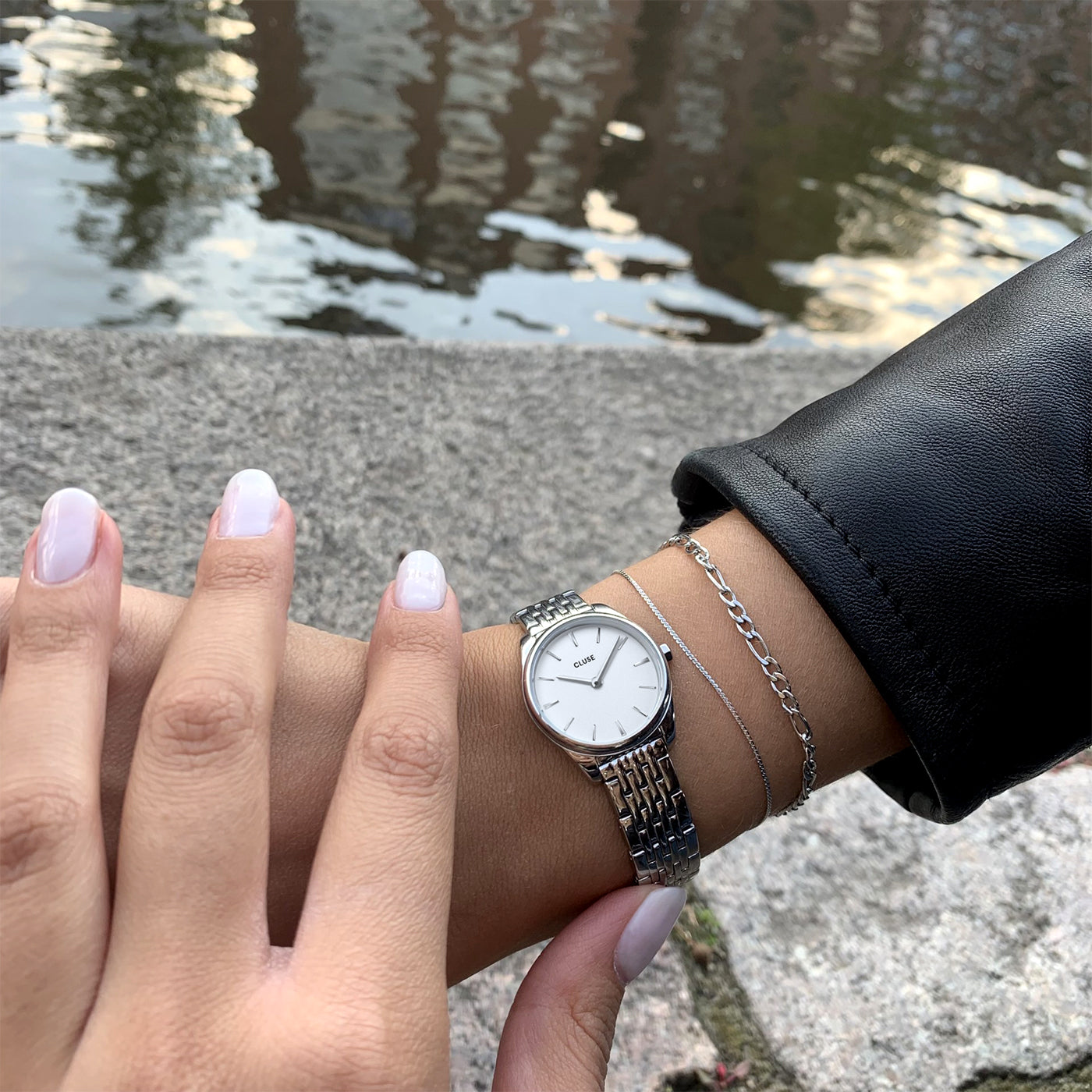 Reloj Cluse Féroce Mini White Silver estilizado junto a accesorios Cluse