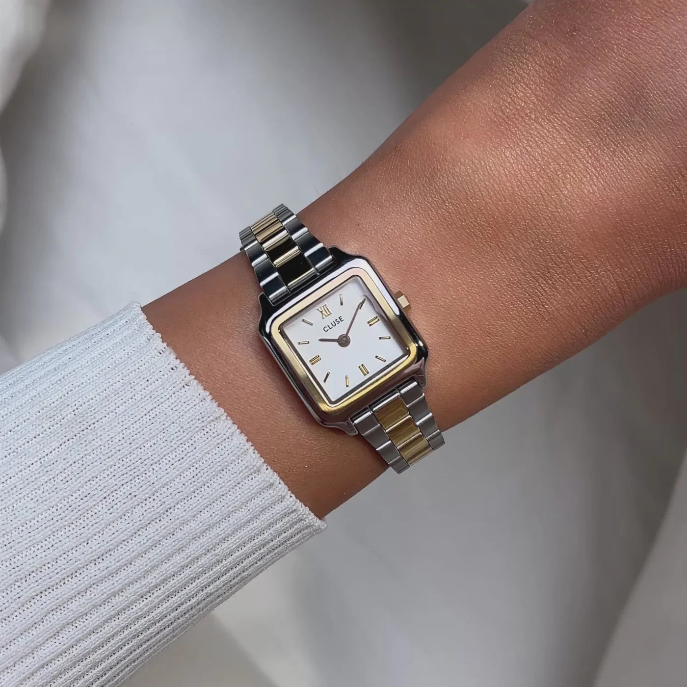 Reloj Cluse Gracieuse Mini Bicolor en muñeca, diseño cuadrado dorado y plateado