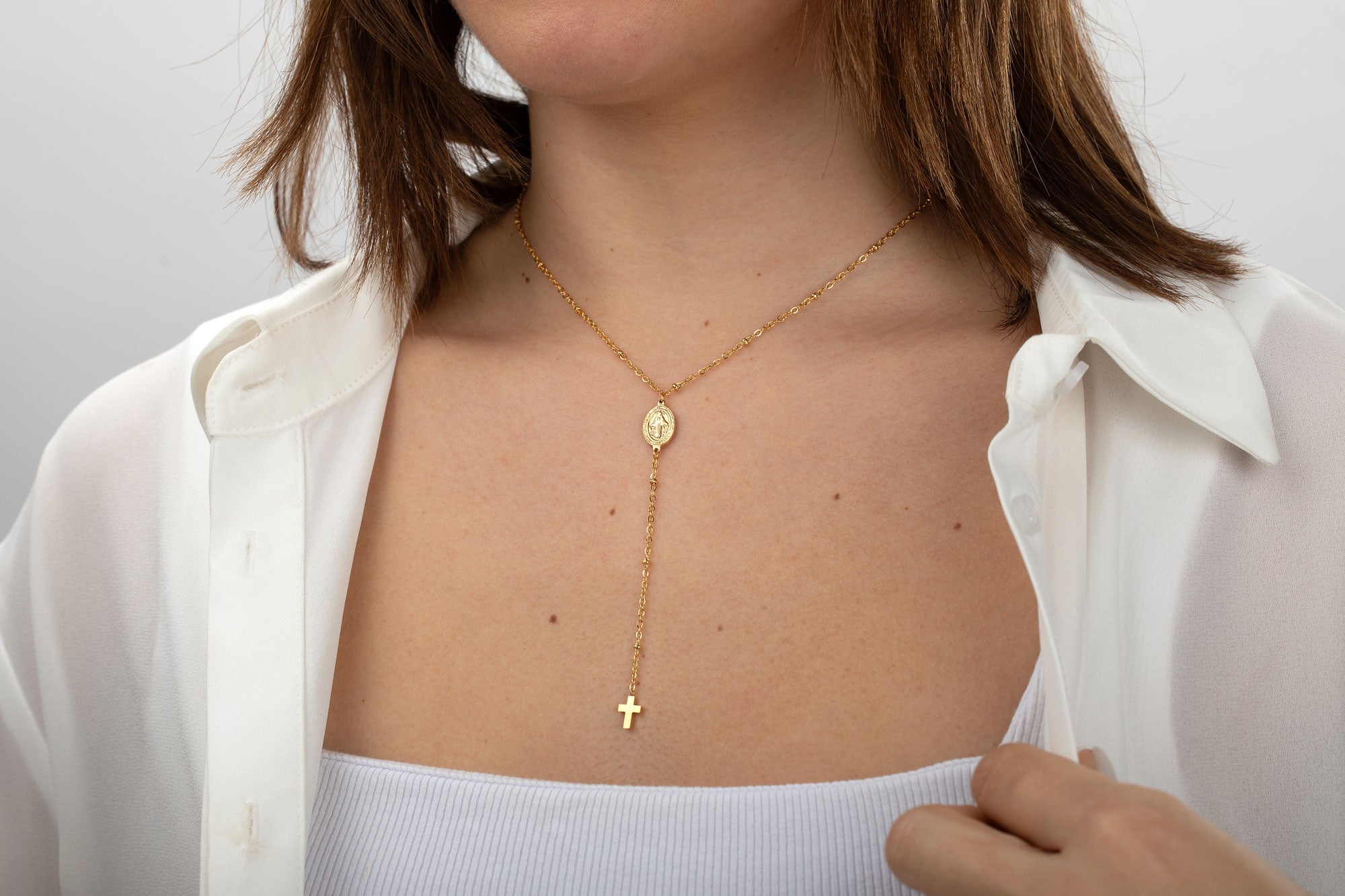 Collar rosario dorado con virgen y cruz puesto en modelo, acero 316L