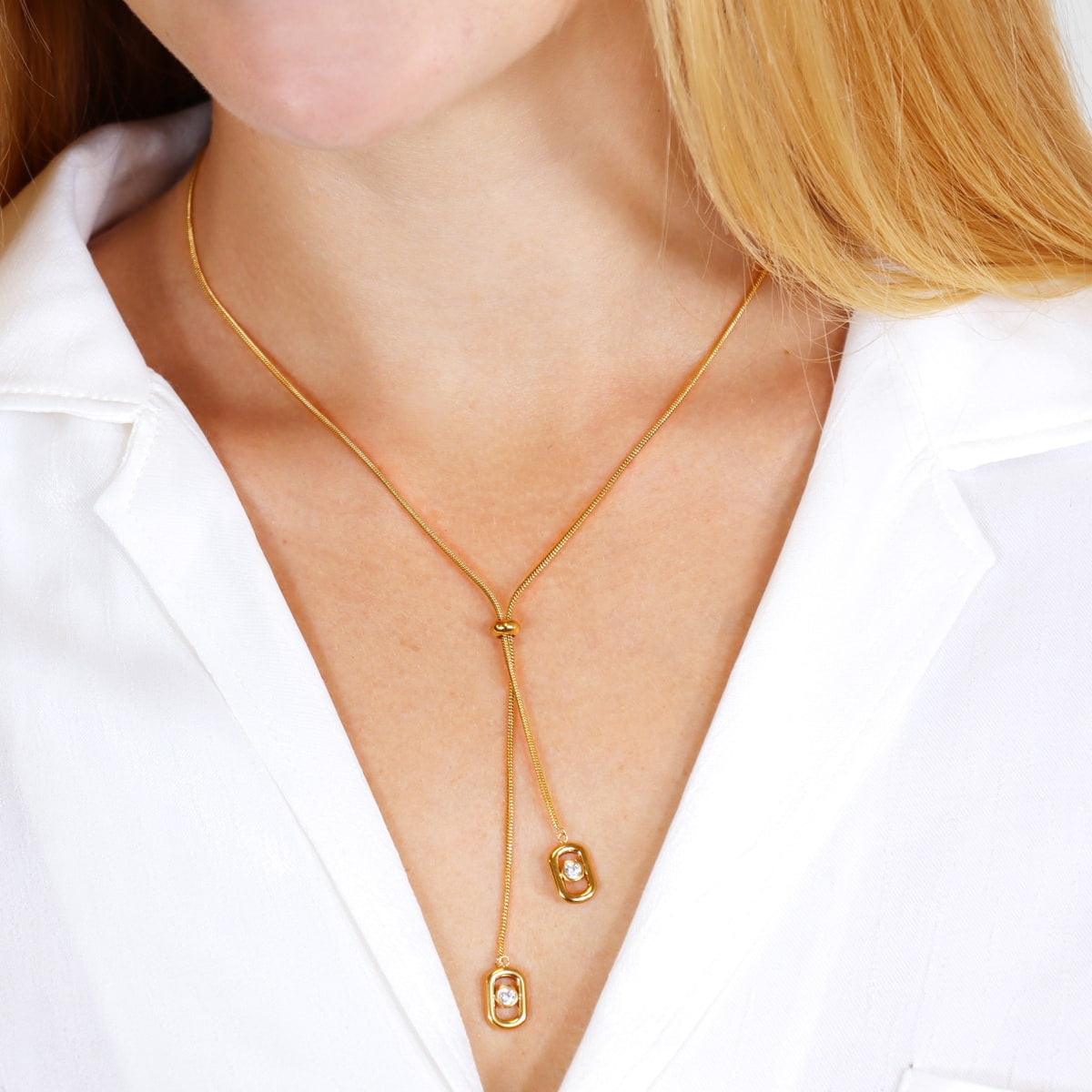 Mujer luciendo Collar Infinity Eternal dorado con circonitas sobre blusa blanca