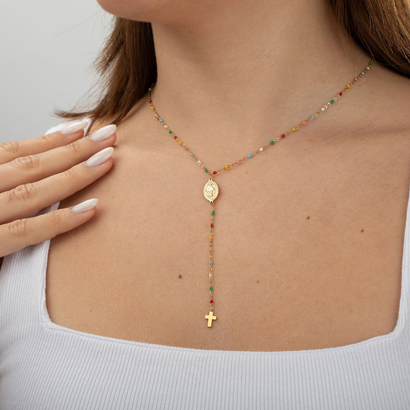 Collar rosario multicolor dorado con Virgen y cruz puesto en cuello estilo elegante