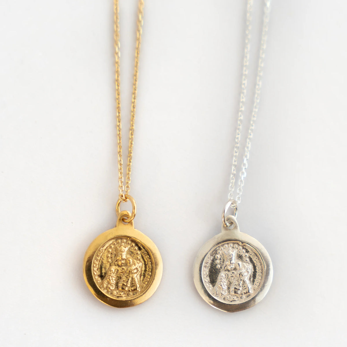 Medalla de la Virgen de los Desamparados en dorado y en plata, una junto a otra