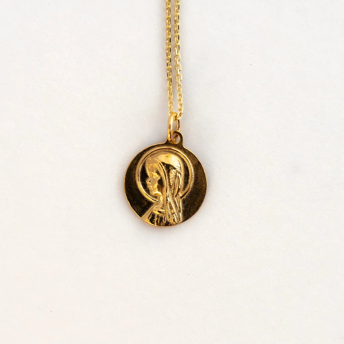 Medalla de la Virgen Niña de 16 mm en plata de ley con baño de oro, montada en cadena fina