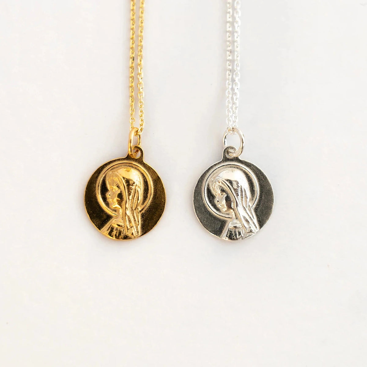 Medalla de la Virgen Niña en dorado y en plata, una junto a otra