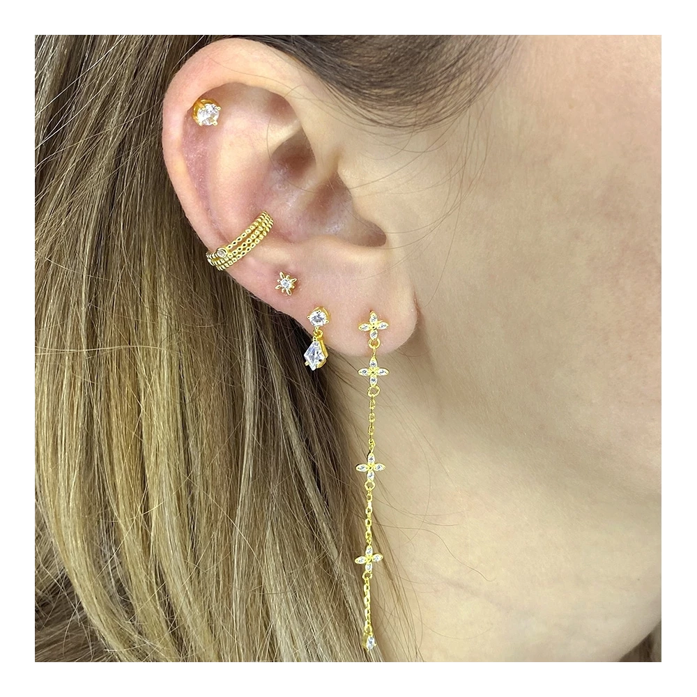 Pendiente Estrella Mini dorado con circonita blanca, combinado con otros pendientes de Cobalto Accesorios en oreja femenina.