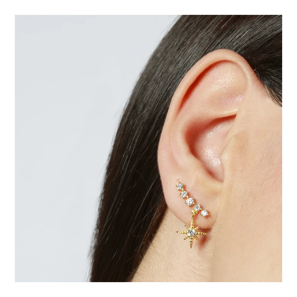 Detalle pendiente trepador Estrella de Luz con circonitas blancas, joya dorada elegante de Cobalto Accesorios en oreja de modelo