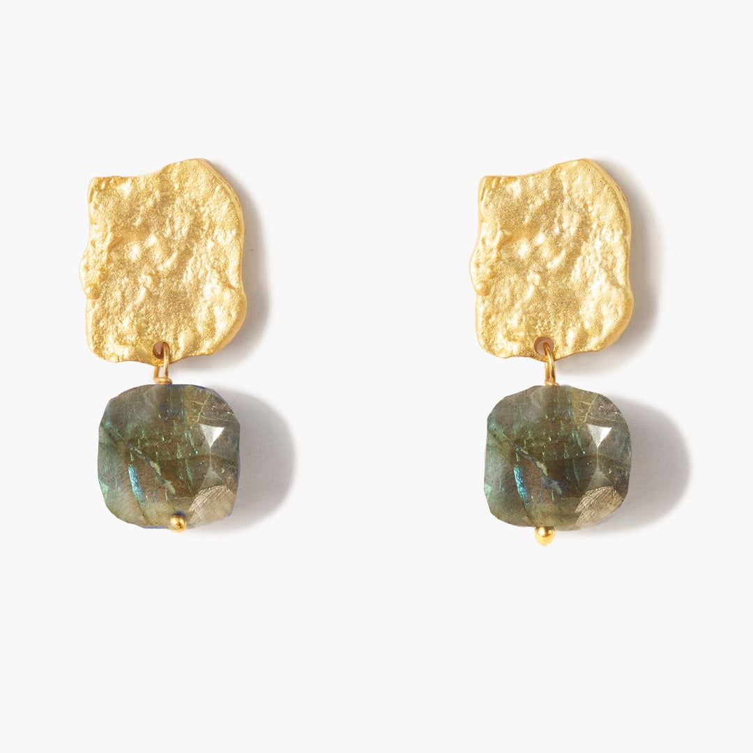 Pendientes Bruma con acabado dorado texturizado y piedra labradorita facetada en tono gris verdoso sobre fondo blanco.
