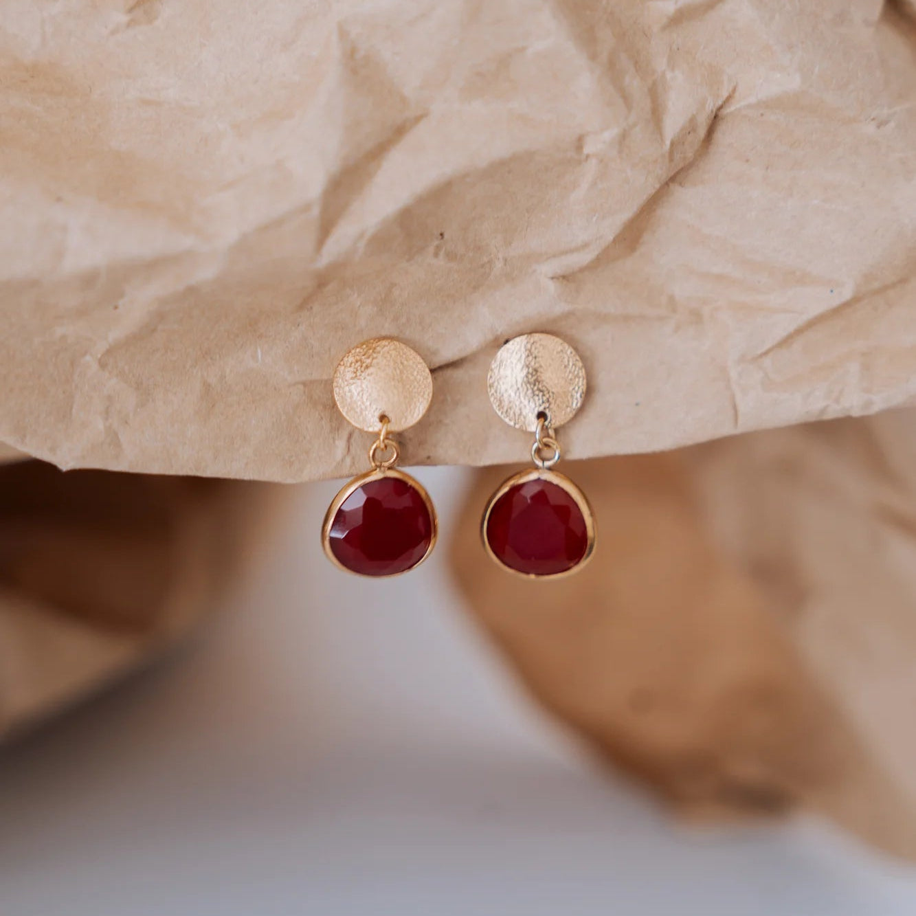 Pendientes chapita dorada con ágata roja sobre papel kraft - Cobalto Accesorios Valencia