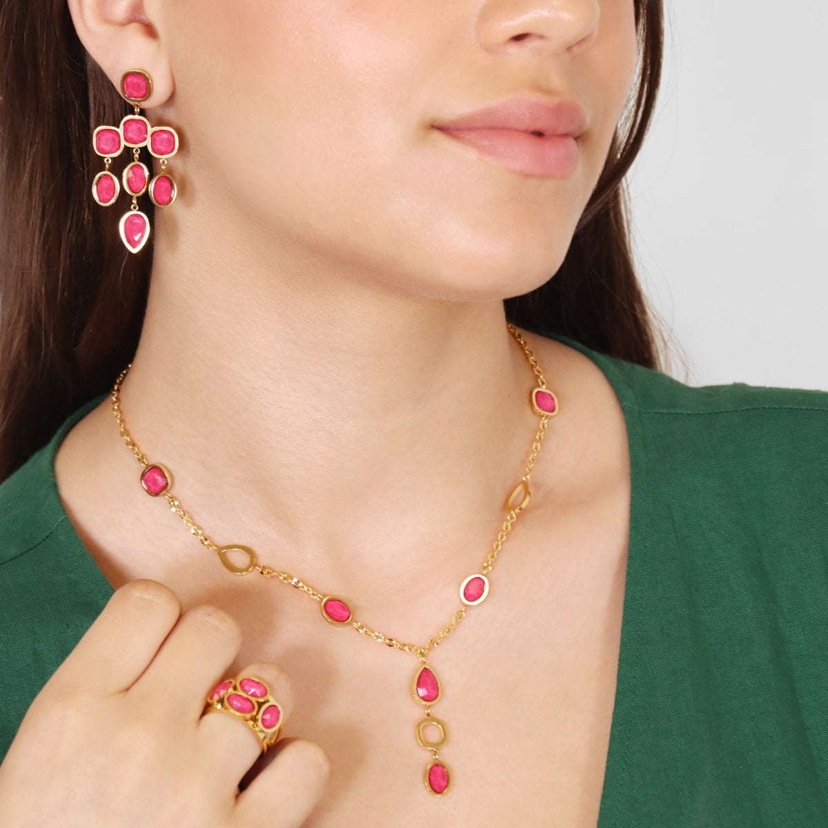 Modelo con pendientes dorados y cristales fucsia brillantes
