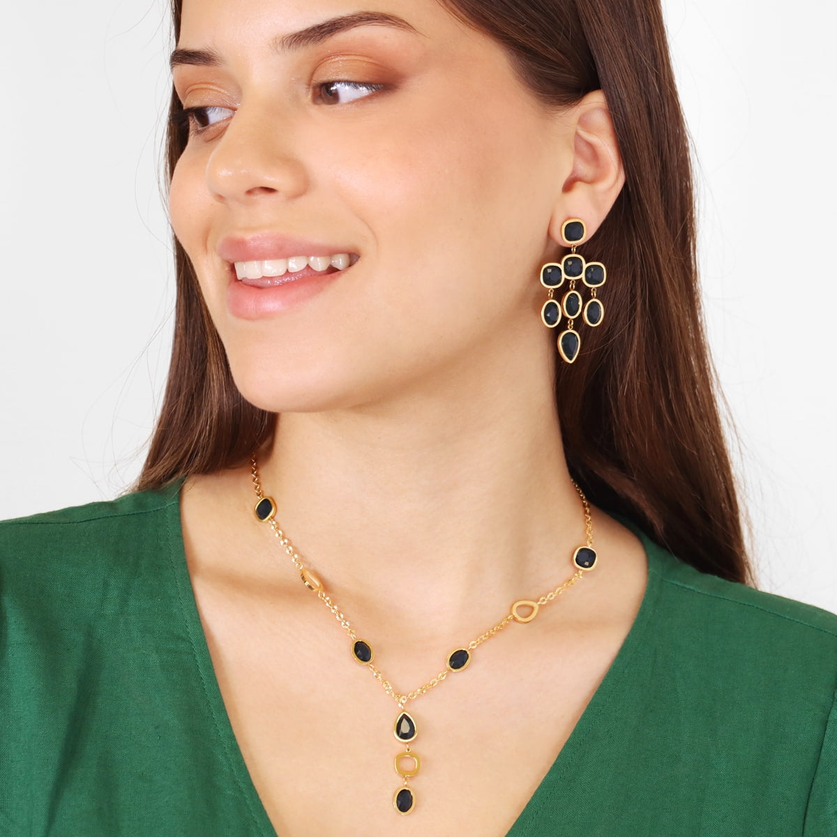 Modelo con pendientes de cristales negros y base dorada
