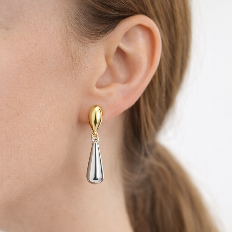 Modelo luciendo pendientes gota dúo bicolor de acero quirúrgico, dorado y plateado, 32 mm