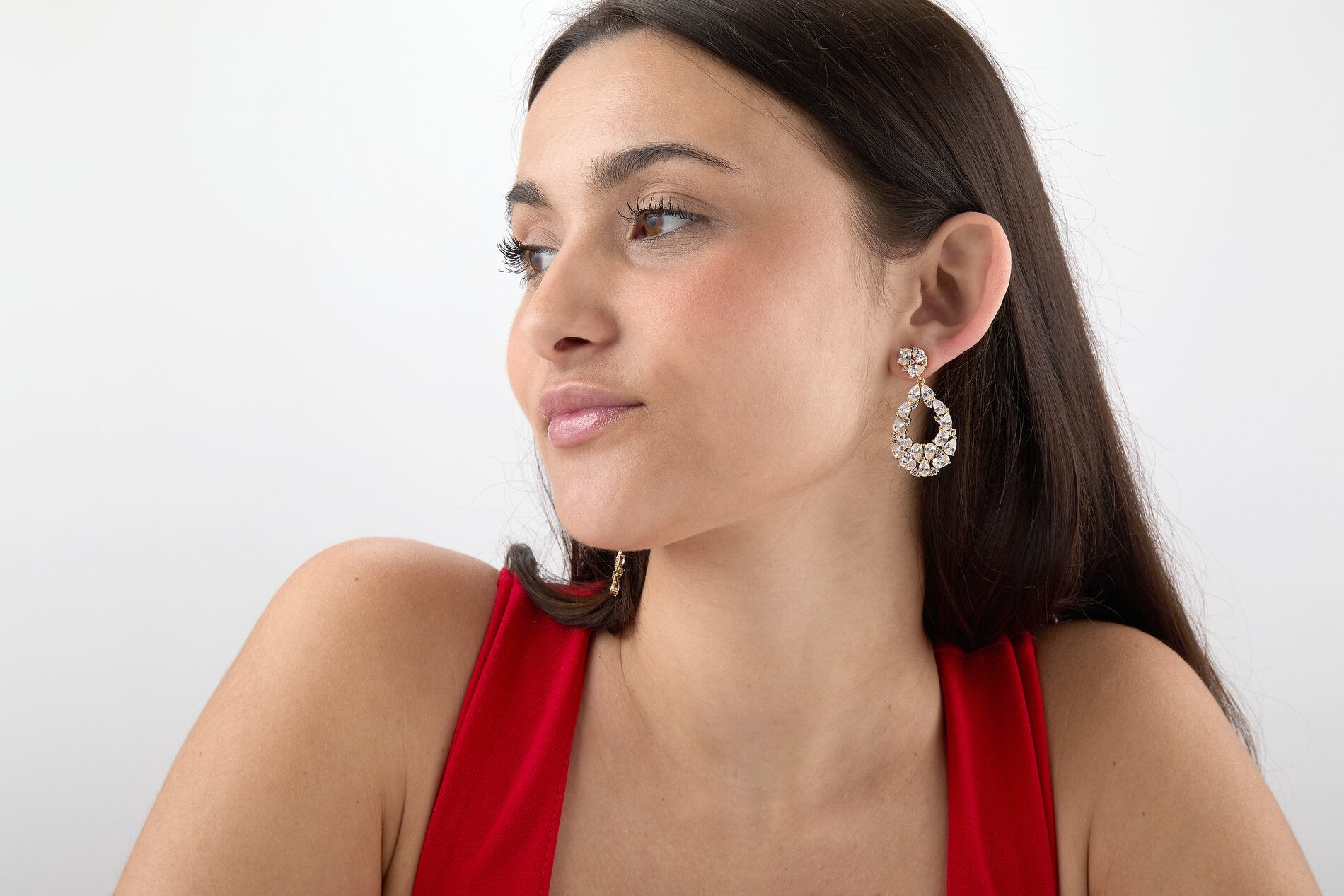 Modelo llevando pendientes Prisma blancos con circonitas brillantes y acabado dorado
