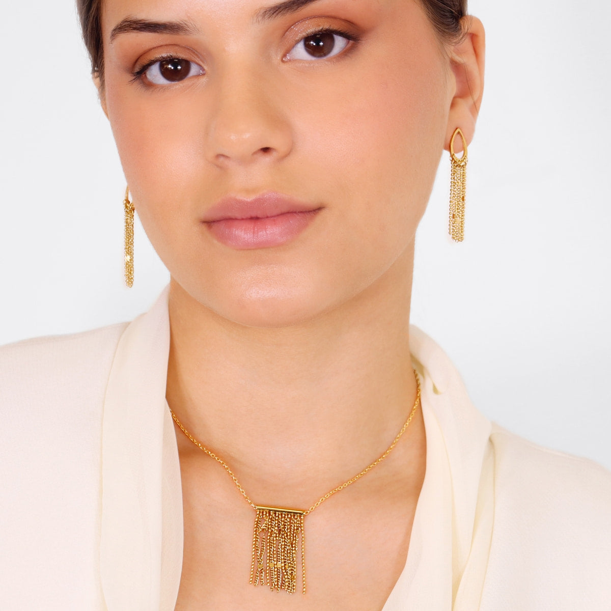 Pendientes dorados combinados con collar a juego de cadenas para look sofisticado