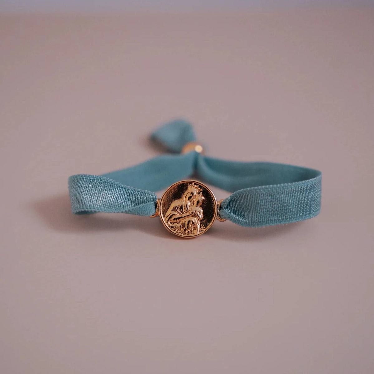 Pulsera escapulario dorada con cinta elástica azul