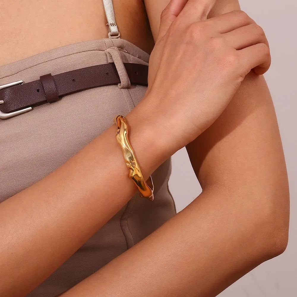 Detalle de pulsera esclava dorada martilleada, pieza de acero con acabado trabajado