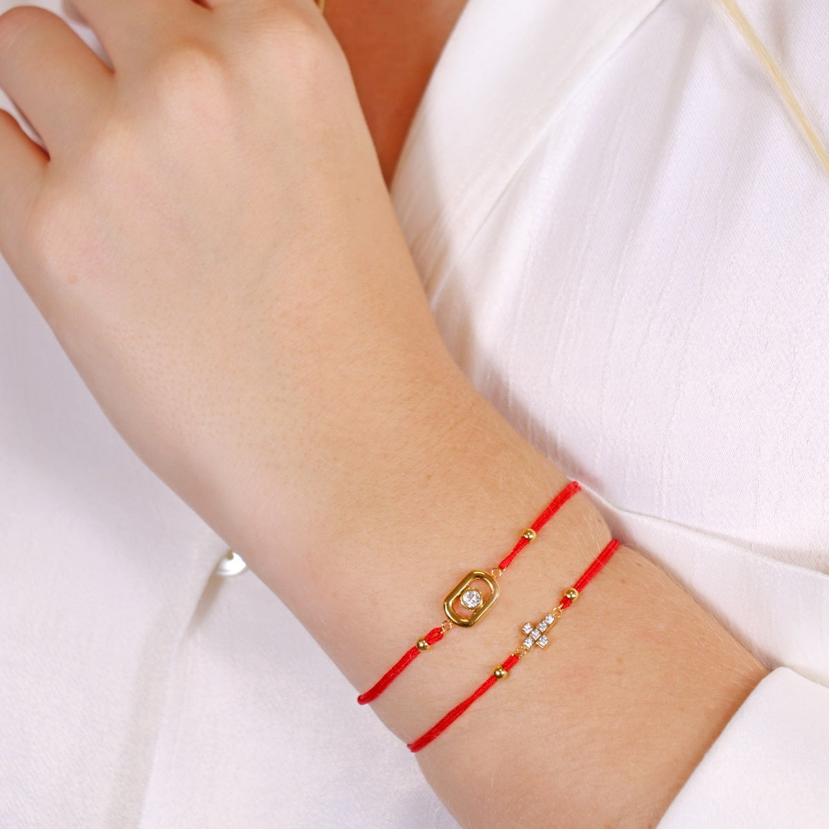 Pulsera Infinity Cross hilo rojo con cruz de circonitas doradas en modelo