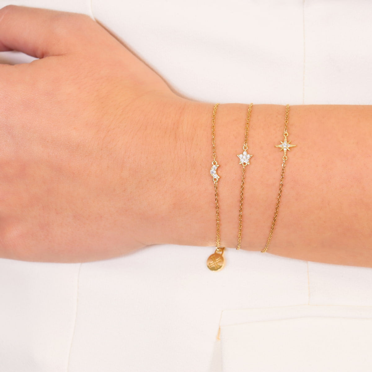 Pulsera Rosa de los Vientos Mini de Acero 316L puesta en la muñeca con otras pulseras finas
